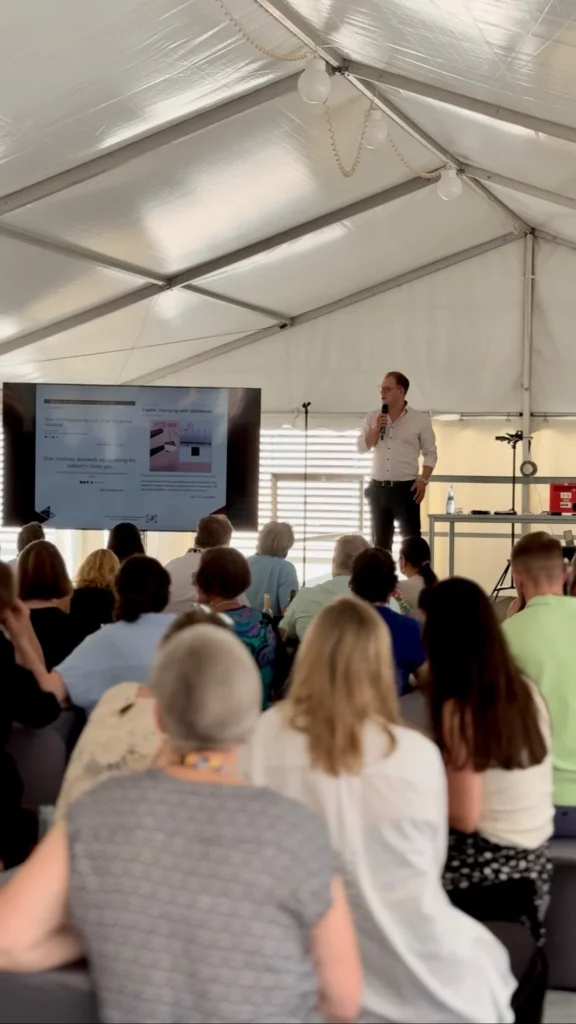 Vortrag beim Burger Branchentreff unter einem Zelt, ein Referent spricht vor einem Publikum aus Goldschmieden und Juwelieren. Der Burger Branchentreff bringt Fachleute aus der Edelmetallbranche zusammen.