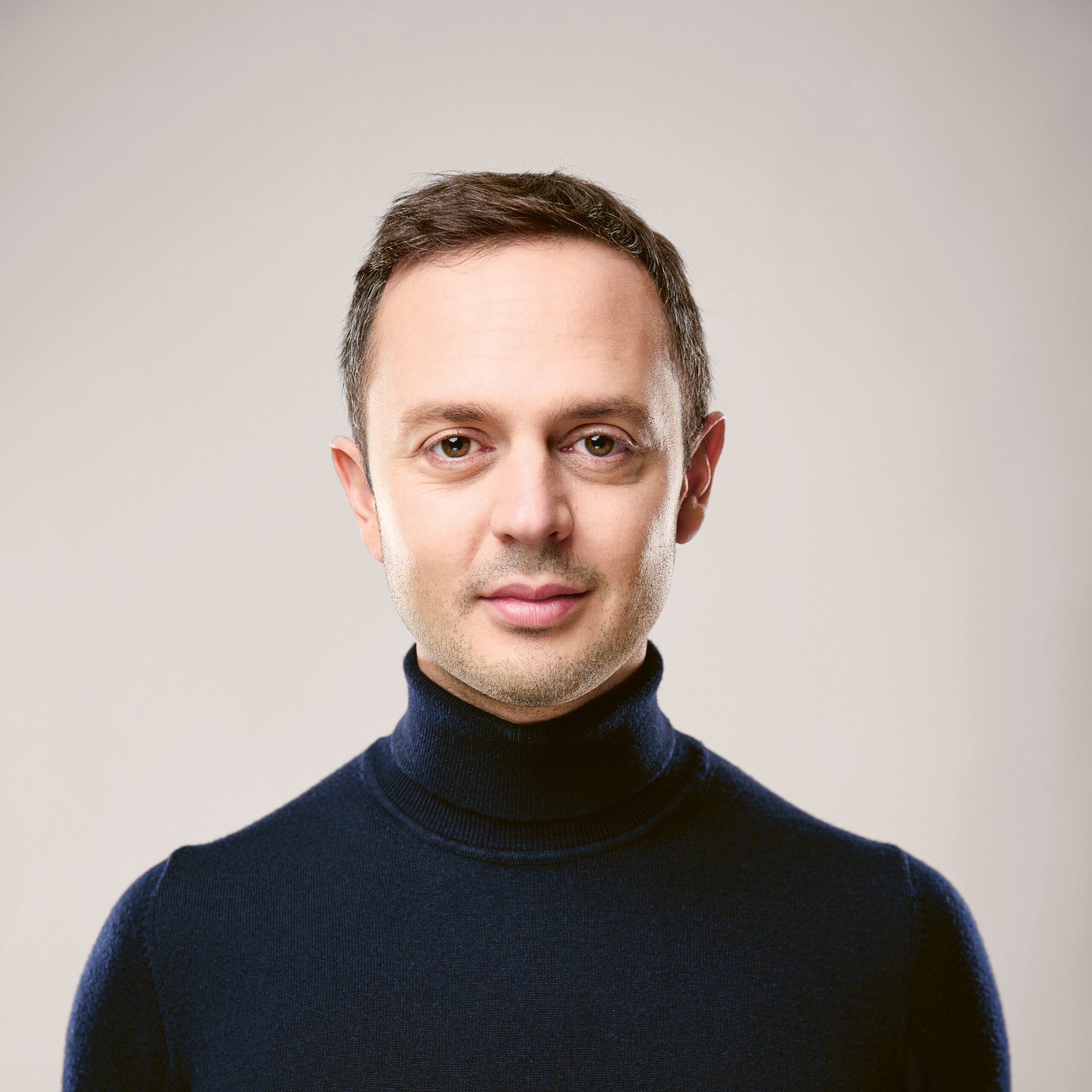 Camille Burger, Geschäftsführer der Dr. Bernhard Burger AG, im professionellen Portrait mit dunklem Rollkragenpullover vor hellem Hintergrund. Er leitet das Familienunternehmen Burger Edelmetalle seit 2024.