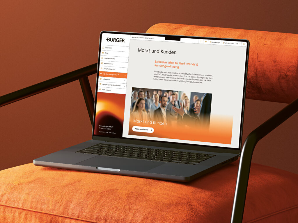 Laptop auf orangefarbenem Stuhl zeigt das Burger Center – die Online-Plattform von Burger Edelmetalle für Marktinformationen und Kundenverwaltung. Das Burger Center ist rund um die Uhr erreichbar.