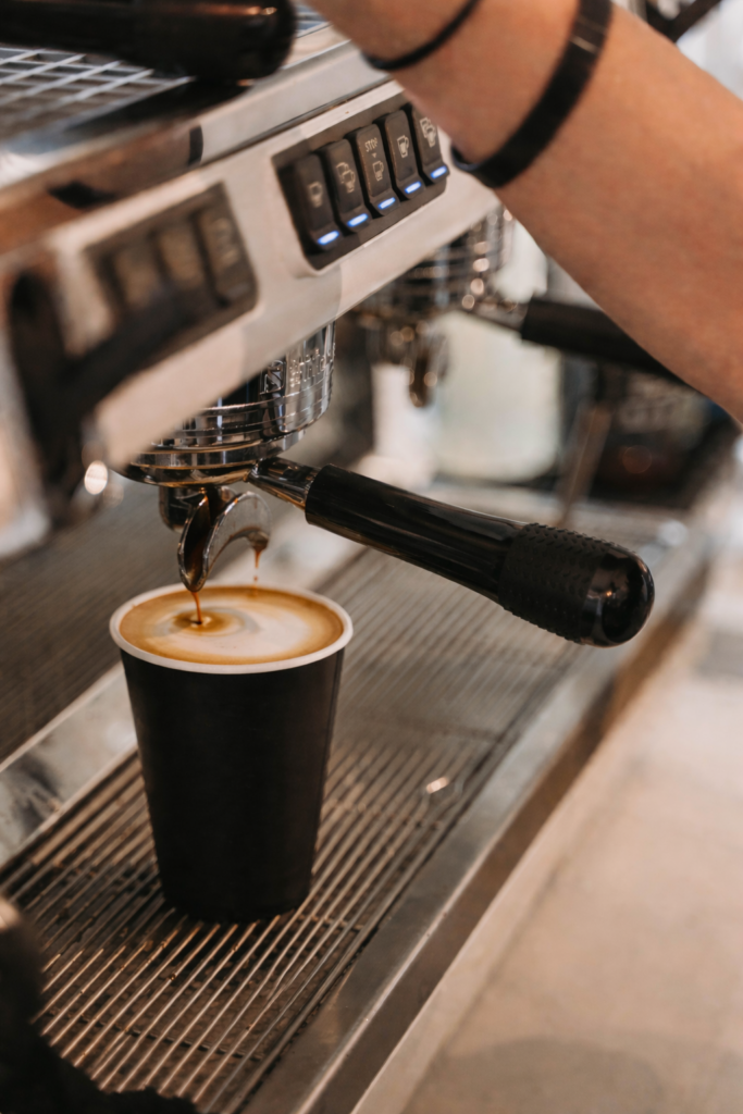 Espresso fließt an der Burger Edelmetalle Kaffebar auf einer Messe in einen schwarzen Becher. Die Kaffebar ist Teil des gastfreundlichen Messeauftritts von Burger auf Veranstaltungen wie der Inhorgenta.