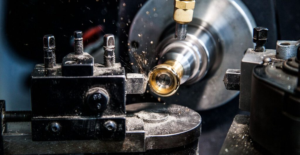 Nahaufnahme einer Metalldrehmaschine bei der Ringproduktion von Burger Edelmetalle, bei der Funken aus dem rotierenden Werkstück sprühen. Die hauseigene Fertigung garantiert höchste Qualität bei Edelmetall-Ringrohlingen.