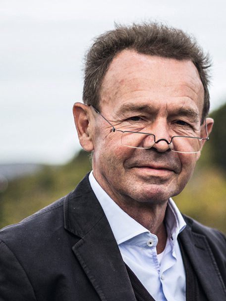 Dr. Bernhard Burger, Gründer der Dr. Bernhard Burger AG, im Portrait mit Brille und dunklem Blazer vor natürlichem Hintergrund im Freien. Er gründete die Scheideanstalt Burger Edelmetalle 1998 in Keltern und prägte das Unternehmen bis zu seinem Tod.