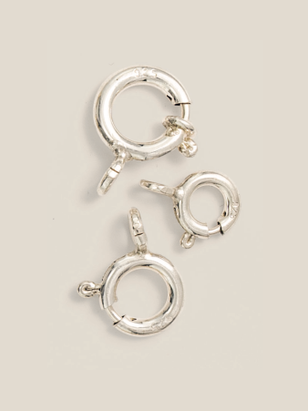 Edelmetall-Federringe und Ringkarabiner von Burger in verschiedenen Größen auf hellem Hintergrund. Die Schmuck-Furnituren sind in Gold, Silber und weiteren Legierungen ohne Mindestmenge bestellbar.