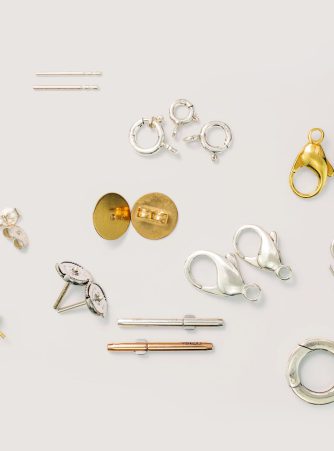 Großes Sortiment an Edelmetall-Furnituren von Burger – Ohrstecker, Karabiner, Federringe und weitere Schmuckverschlüsse in Gold, Silber und Rosegold auf weißem Hintergrund. Alle Furnituren sind ohne Mindestmengen bestellbar.