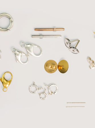 Großes Sortiment an Edelmetall-Furnituren von Burger – Ohrstecker, Karabiner, Federringe und weitere Schmuckverschlüsse in Gold, Silber und Rosegold auf weißem Hintergrund. Alle Furnituren sind ohne Mindestmengen bestellbar.