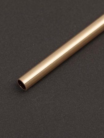 Ein Gelbgold-Rohr liegt diagonal auf dunklem Hintergrund und zeigt sein offenes Ende in Nahaufnahme. Rohre aus Gelbgold gehören zum Halbzeug-Sortiment von Burger Edelmetalle und sind in verschiedenen Durchmessern und Wandstärken erhältlich.
