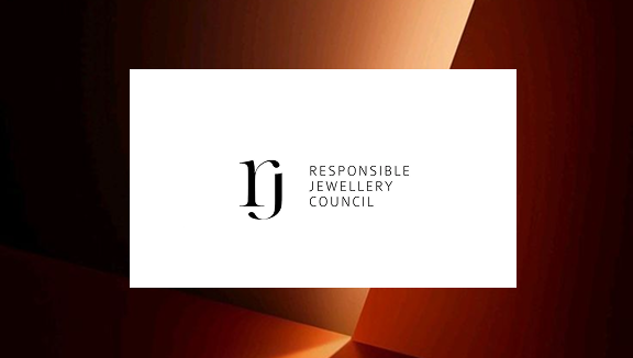 Logo des Responsible Jewellery Council mit den Initialen rj in schwarzen Kleinbuchstaben und dem Text RESPONSIBLE JEWELLERY COUNCIL auf einem weißen Rechteck vor einem braunen abstrakten Hintergrund.